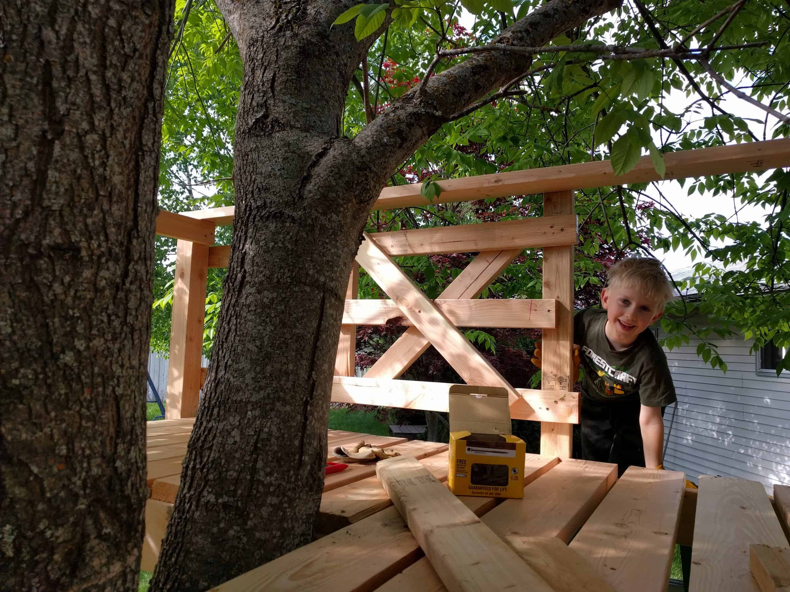 Eli at a side entrace to the tree house, last wall built with an X pattern