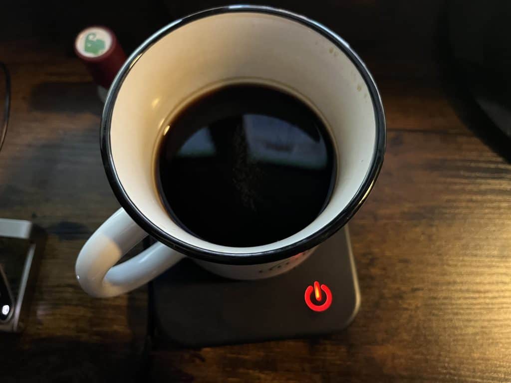 Coffee mug with coffee in it on a warmer