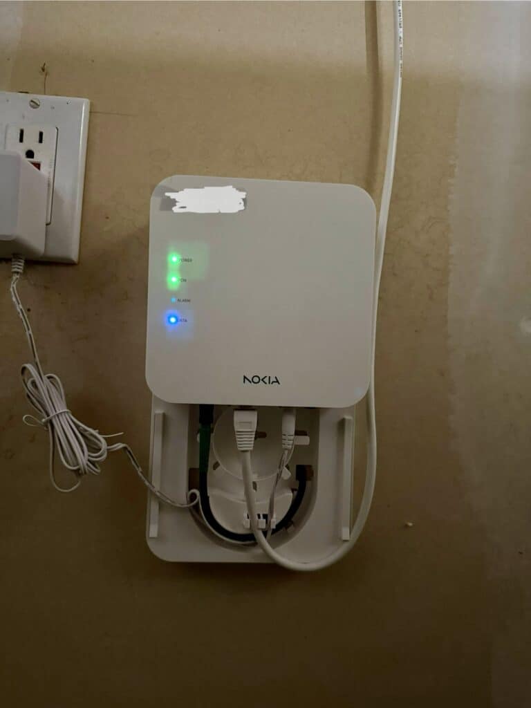 Nokia ONT device mounted on a wall with multiple indicator lights illuminated.
